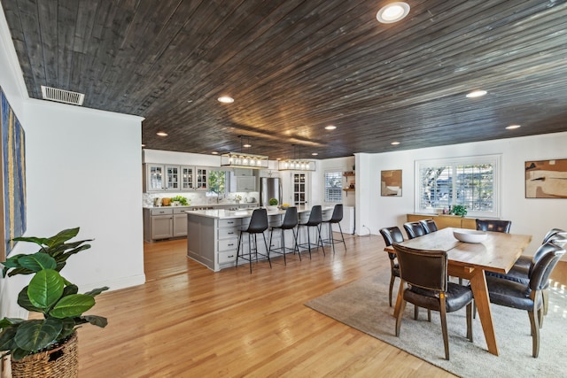 dining room featuring light hardwood / wood-style flooring and wood ceiling