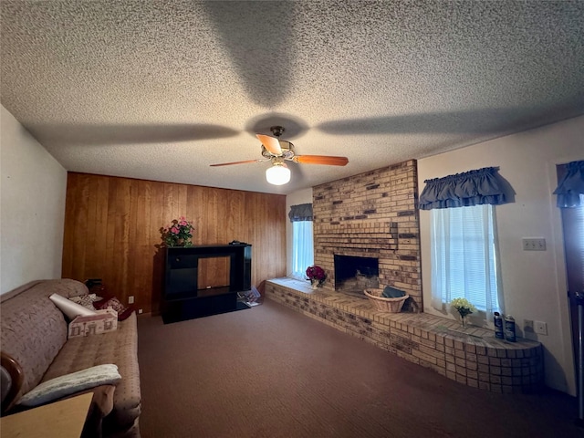 living room featuring a fireplace, a textured ceiling, wood walls, and ceiling fan