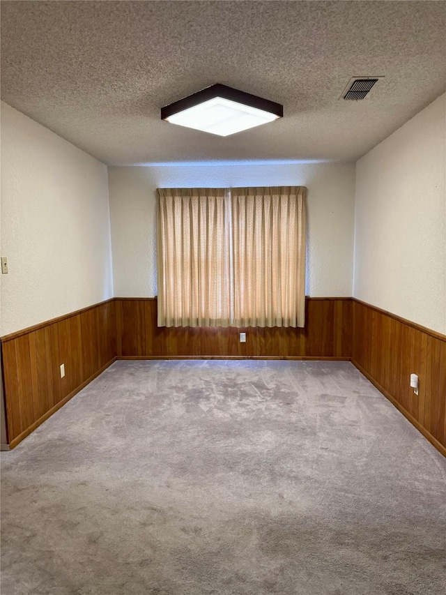 carpeted empty room with a textured ceiling