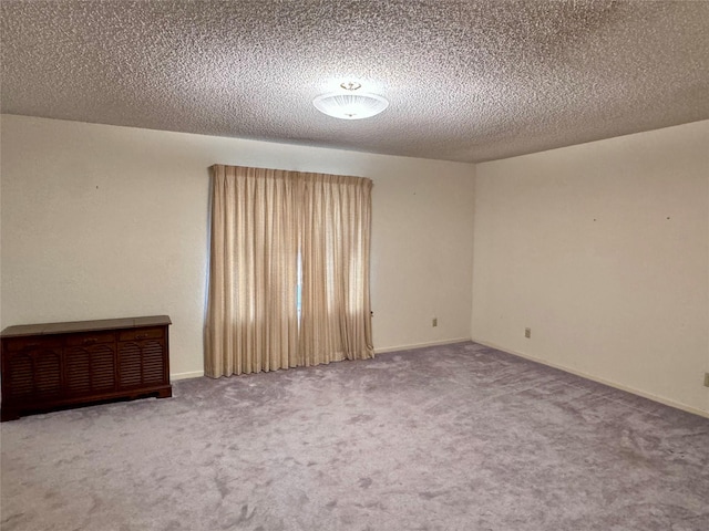 carpeted spare room featuring a textured ceiling