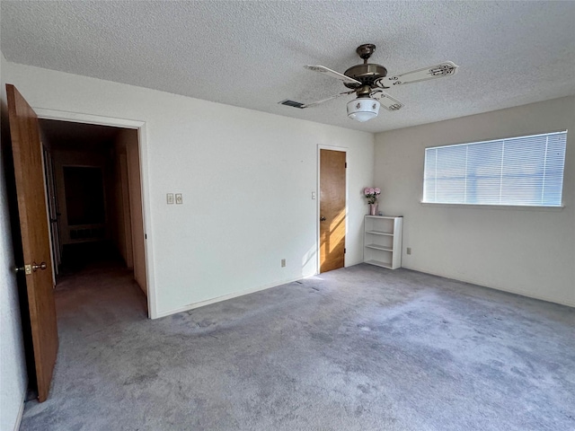 unfurnished bedroom featuring light carpet, ceiling fan, and a textured ceiling