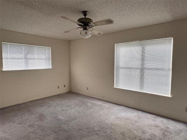 carpeted empty room featuring a textured ceiling and ceiling fan