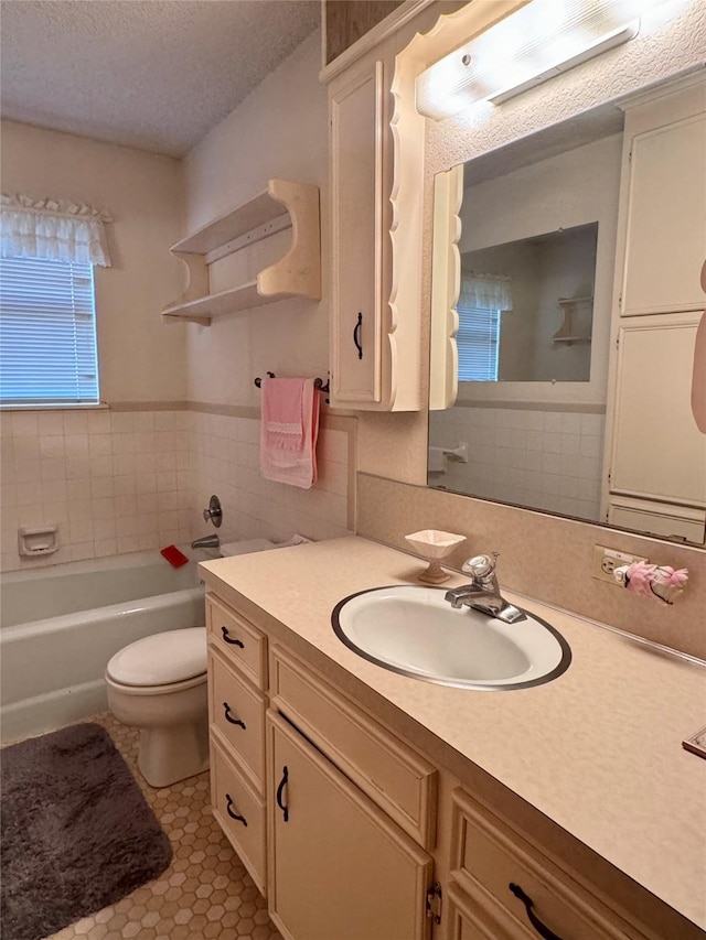 bathroom with toilet, a textured ceiling, a bathing tub, tile patterned floors, and vanity