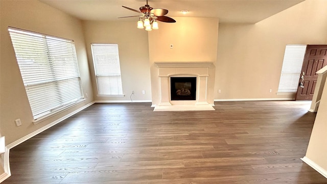 unfurnished living room with dark hardwood / wood-style flooring and ceiling fan