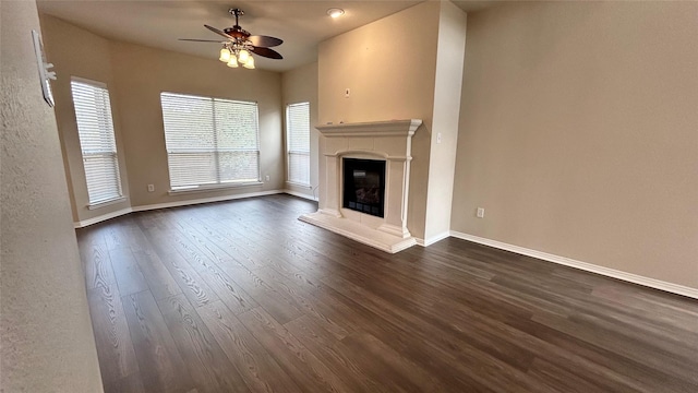 unfurnished living room featuring ceiling fan and dark hardwood / wood-style flooring