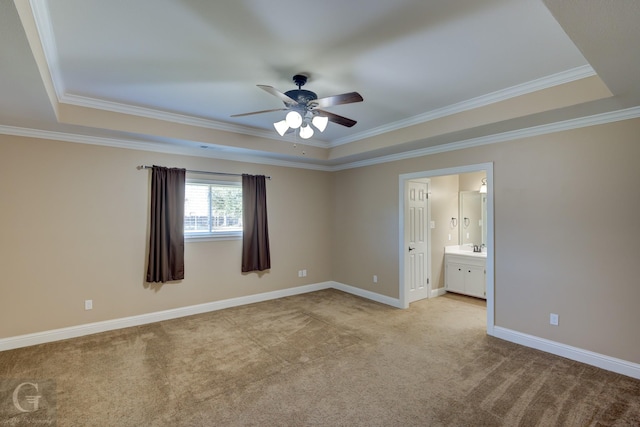 carpeted empty room featuring ceiling fan, a tray ceiling, and crown molding