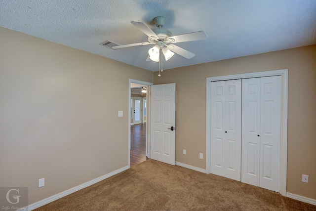 unfurnished bedroom featuring light carpet, a closet, ceiling fan, and a textured ceiling