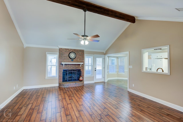 unfurnished living room with vaulted ceiling with beams, ceiling fan, hardwood / wood-style flooring, a brick fireplace, and a wealth of natural light