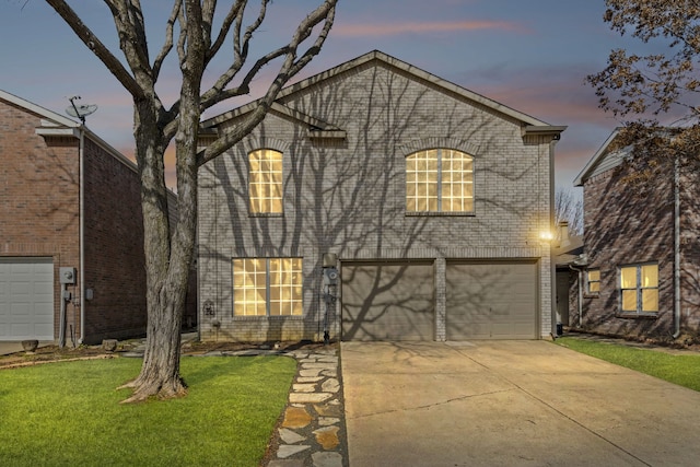 view of front of home featuring brick siding, a lawn, driveway, and a garage