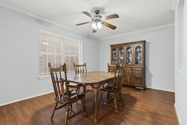 dining space with a textured ceiling, dark wood-type flooring, and ornamental molding