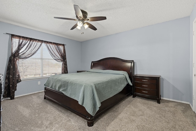 bedroom with a ceiling fan, baseboards, and carpet floors