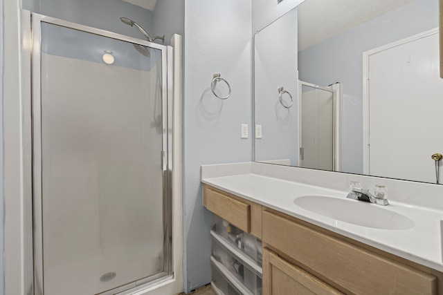 bathroom with a shower stall and vanity