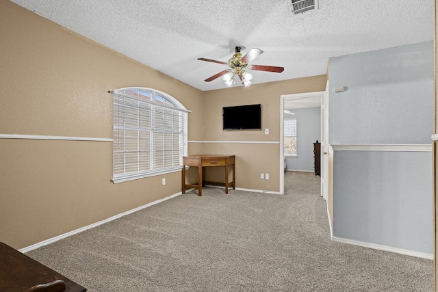 unfurnished bedroom featuring visible vents, a textured ceiling, baseboards, and carpet floors