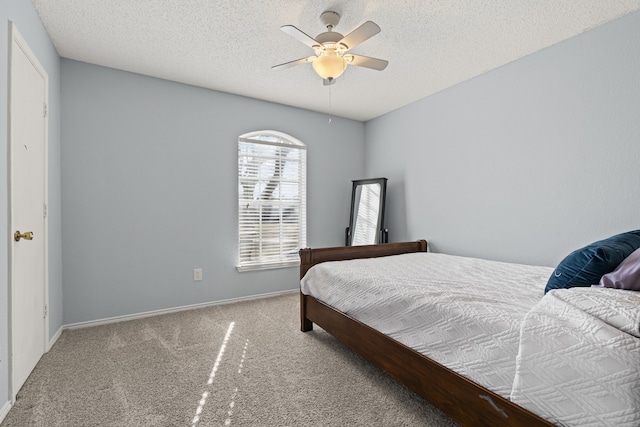 carpeted bedroom featuring ceiling fan, a textured ceiling, and baseboards