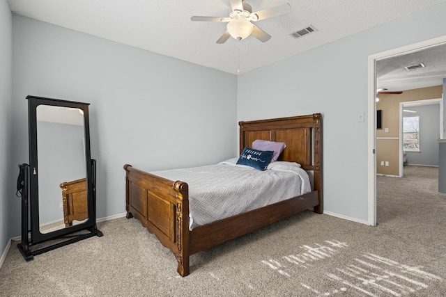 bedroom with a textured ceiling, baseboards, visible vents, and light carpet