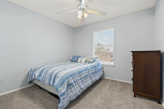 bedroom with light carpet, a ceiling fan, and baseboards