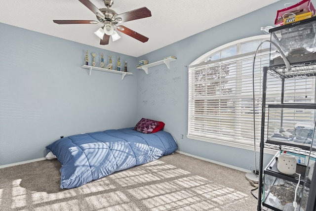 carpeted bedroom with a ceiling fan and baseboards