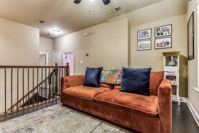 living room featuring ceiling fan and dark wood-type flooring