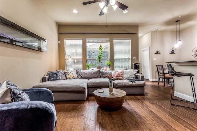 living room featuring ceiling fan and dark hardwood / wood-style flooring