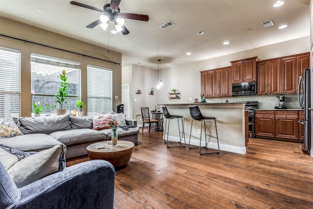 living room with ceiling fan and dark hardwood / wood-style floors