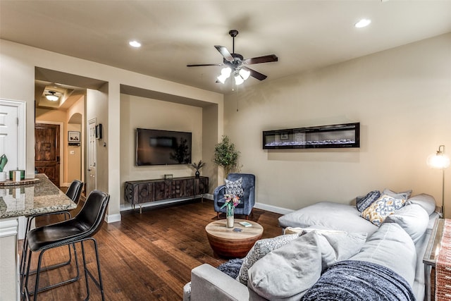 living room with ceiling fan and dark hardwood / wood-style floors