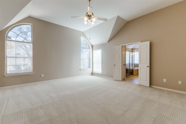 interior space featuring lofted ceiling, light colored carpet, and ceiling fan