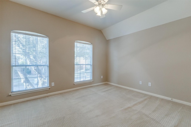 carpeted empty room with ceiling fan and vaulted ceiling