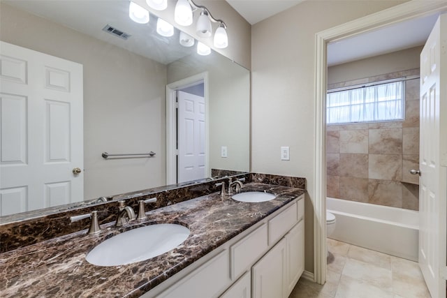 full bathroom with toilet, tiled shower / bath combo, and vanity