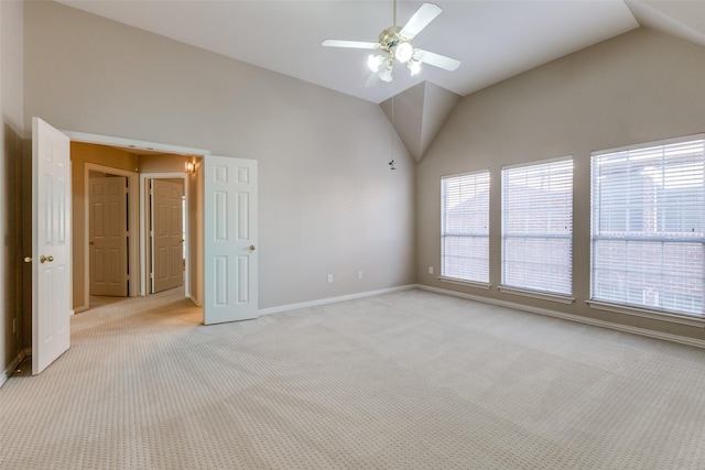 empty room featuring lofted ceiling, ceiling fan, and light colored carpet