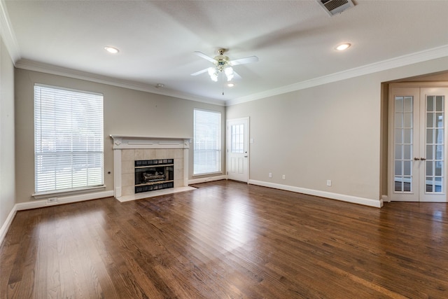 unfurnished living room featuring ceiling fan, ornamental molding, a healthy amount of sunlight, and dark hardwood / wood-style floors