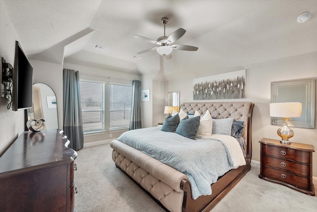 bedroom featuring ceiling fan, light carpet, and a raised ceiling