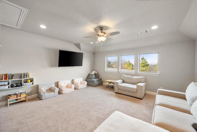 living room featuring lofted ceiling, a textured ceiling, carpet floors, and ceiling fan