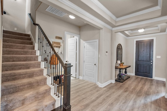 entrance foyer featuring ornamental molding, hardwood / wood-style flooring, and a tray ceiling