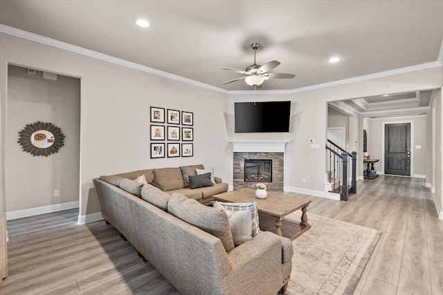 living room with a fireplace, light hardwood / wood-style floors, and crown molding