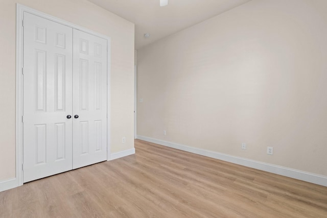 unfurnished bedroom with light wood-type flooring and a closet