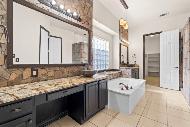 bathroom with vanity, tile patterned flooring, a tub to relax in, and tasteful backsplash