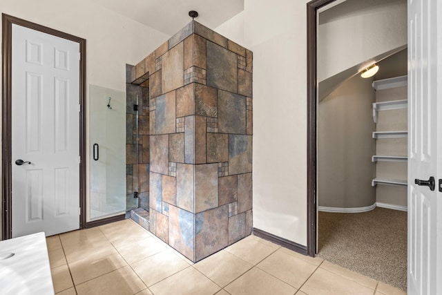 bathroom with a shower with door and tile patterned floors