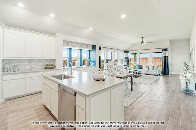 kitchen featuring dishwasher, a center island with sink, lofted ceiling, white cabinets, and sink