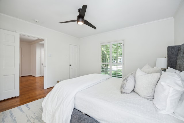 bedroom featuring dark wood-type flooring, ceiling fan, and crown molding