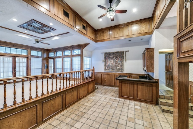 kitchen with brown cabinetry, dark countertops, ceiling fan, a peninsula, and recessed lighting