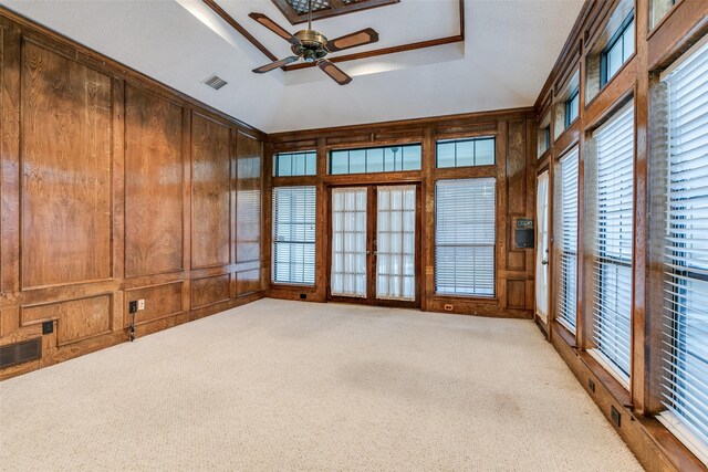 interior space featuring light tile patterned floors, a skylight, a chandelier, and wood walls