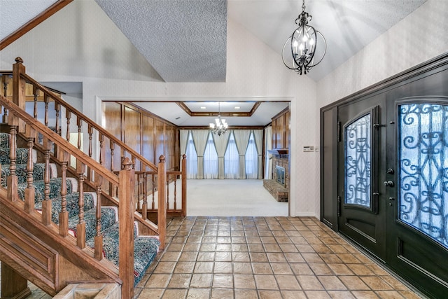 carpeted foyer entrance with lofted ceiling, crown molding, stairway, and a notable chandelier