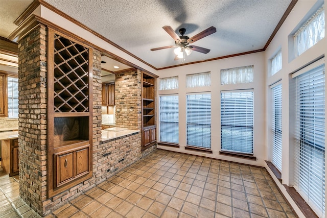 interior space featuring ornamental molding, a textured ceiling, built in features, and a ceiling fan