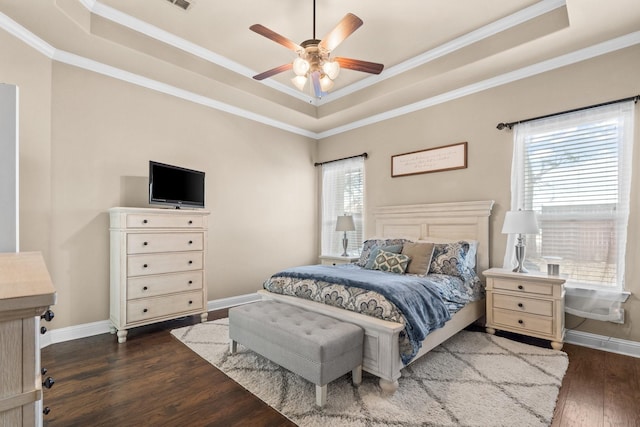 bedroom featuring ceiling fan, a tray ceiling, ornamental molding, and dark hardwood / wood-style floors