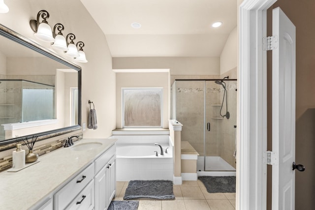 bathroom with tile patterned flooring, vaulted ceiling, plus walk in shower, and vanity