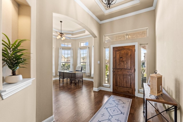 foyer entrance featuring ornamental molding, ceiling fan, a raised ceiling, and dark hardwood / wood-style floors