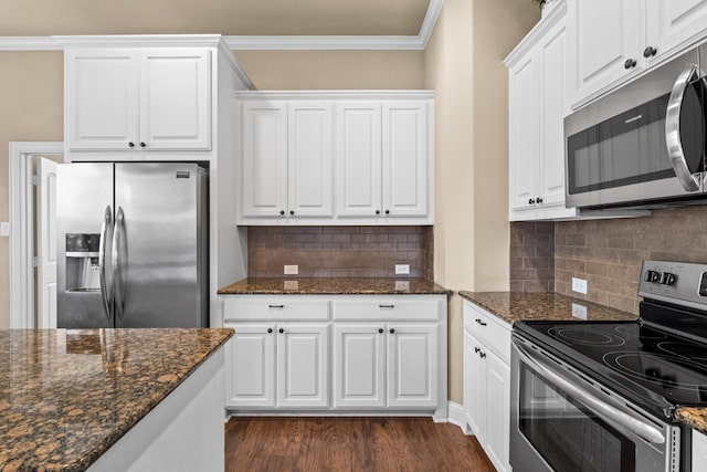 kitchen featuring stainless steel appliances, crown molding, dark hardwood / wood-style flooring, white cabinetry, and dark stone counters