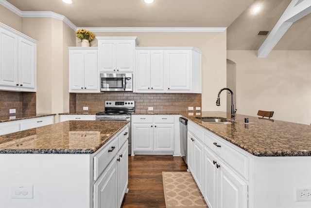 kitchen with dark stone countertops, stainless steel appliances, dark hardwood / wood-style flooring, sink, and white cabinetry