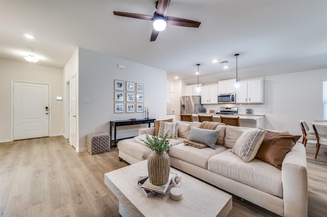 living room featuring ceiling fan and light hardwood / wood-style flooring