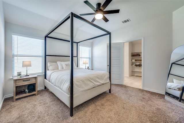 bedroom featuring light colored carpet, ceiling fan, and connected bathroom